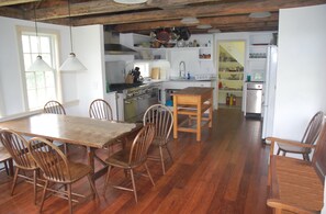 Une cuisine spacieuse avec un plancher en bois, une table à manger et des chaises.