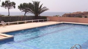 A swimming pool with a clear view of the sea in the background.