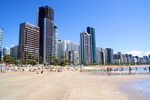A beach with high-rise buildings in the background.