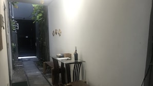 A narrow corridor leading to a dining area with a table and benches. - Flat boa viagem recife /PE (recife)