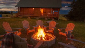 A wooden cabin with a fire pit and Adirondack chairs in front. - Pearadise Peaks* Private Hot Tub, Wifi, 6Br, 3Ba (Island Park)