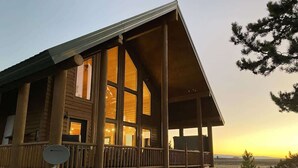 A wooden cabin with large windows, a balcony, and a satellite dish. - Pearadise Peaks* Private Hot Tub, Wifi, 6Br, 3Ba (Island Park)