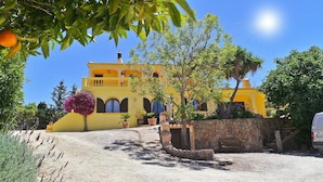 A yellow villa with a stone wall, a balcony, and a statue. - Half hectare property, 6 comfort rooms w/private AC&Bathroom, garden, pool, 4-12 persons (Alvor)