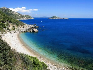 A coastal landscape with clear blue waters, a sandy beach, rocky outcrops, and distant islands. - VILLA DANTE AD UN PASSO DAL MONDO!!!! (Orbetello)