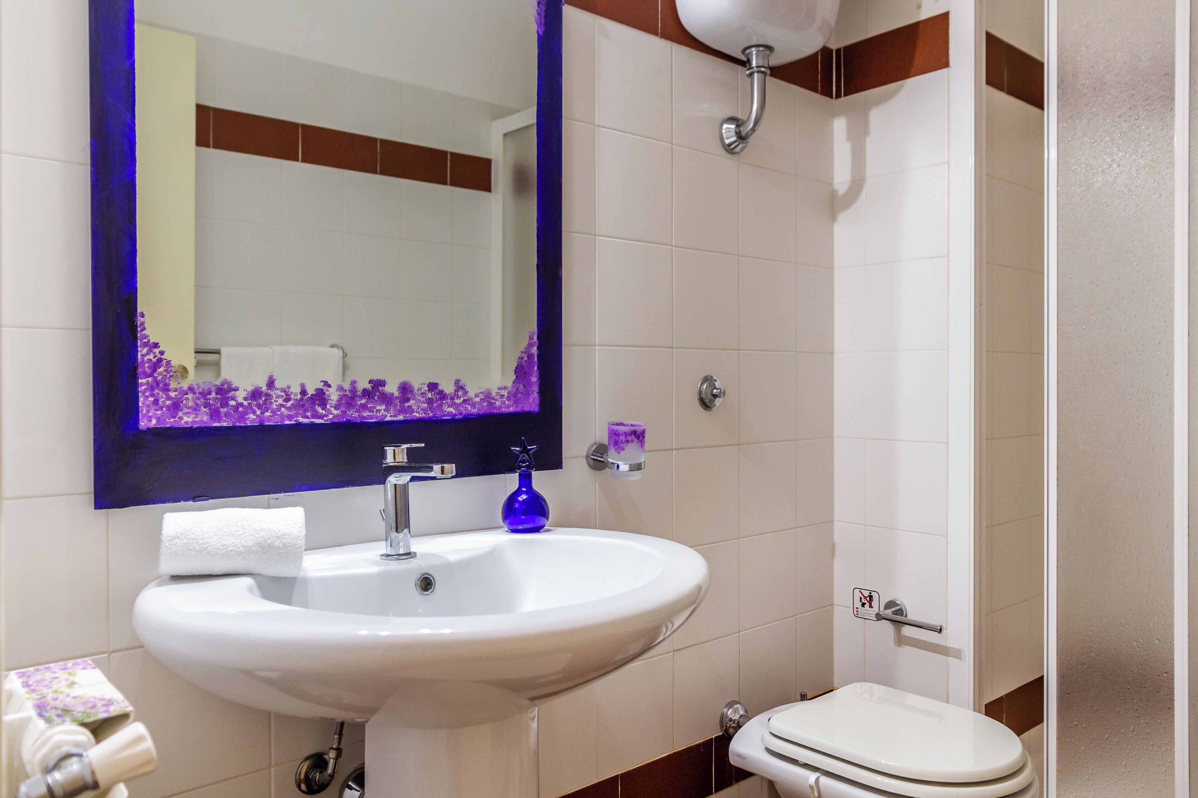A bathroom with a white sink, a mirror, and a toilet.