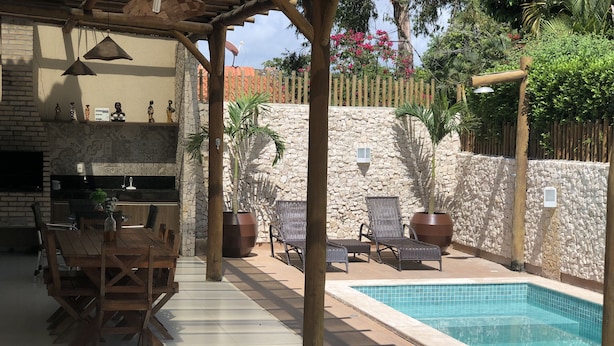 Un'area patio con piscina, pareti in pietra e mobili da esterno.