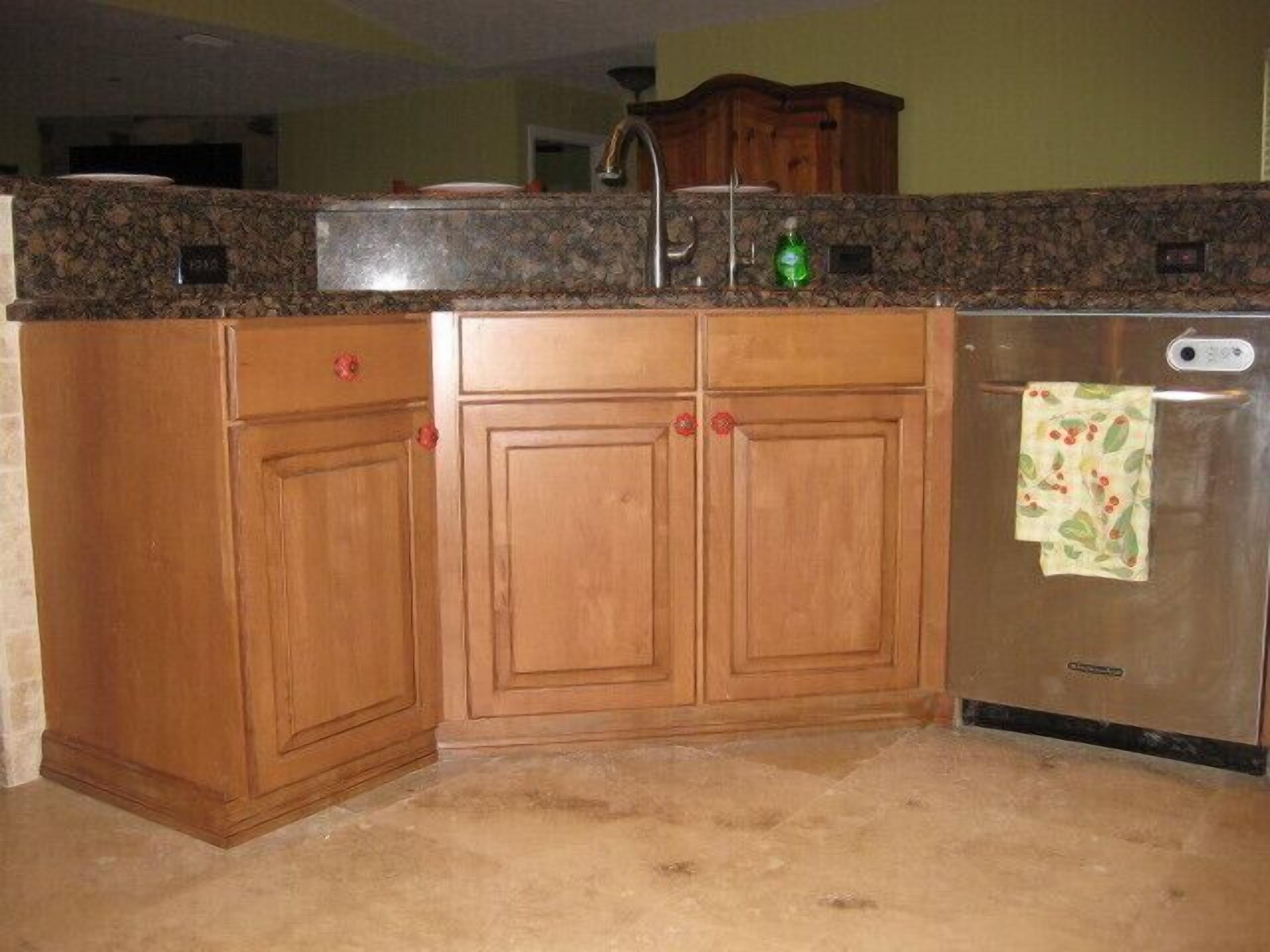 A kitchen with wooden cabinets, a granite countertop, and a stainless steel refrigerator.