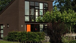 Ein modernes, zweistöckiges Gebäude mit großen Fenstern und einer Ziegelaußenwand.