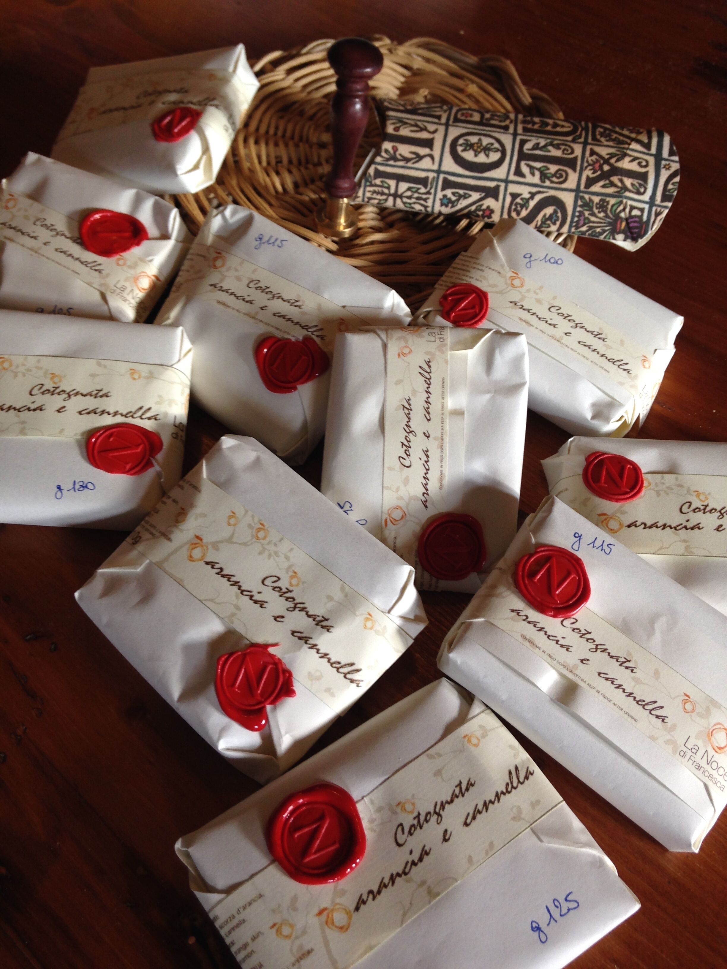 Several wrapped gifts with red wax seals on a wooden table.