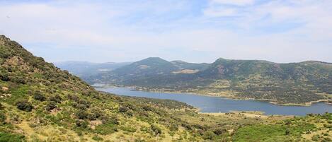 A mountainous landscape with a lake and scattered buildings.