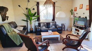 A living room with a sofa, two armchairs, a coffee table, a TV, and a large plant. - House with private pool, in a quiet location close to Mimizan.  (Saint-Paul-en-Born)