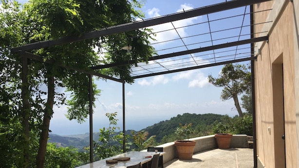 An outdoor patio with a table and chairs, surrounded by potted plants and overlooking a scenic landscape. - House PANORAMIC VIEW SEA between SEA and MOUNTAIN  (Nocera terinese)