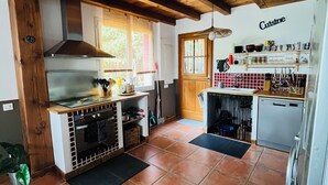 Una cocina con vigas de madera, estufa, horno y lavaplatos.