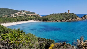 A coastal landscape with a beach, a hill with a tower, and a clear blue sea. - Luxury villa 5 * panoramic sea view private heated pool + SPA (Conca)