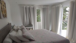 A bedroom with a bed, pillows, and a window with curtains. - Home. Spectacular, 5 Suites, High Standard, ITACIMIRIM. CONDITION QUINTA DAS LAGOAS.  (Camaçari)