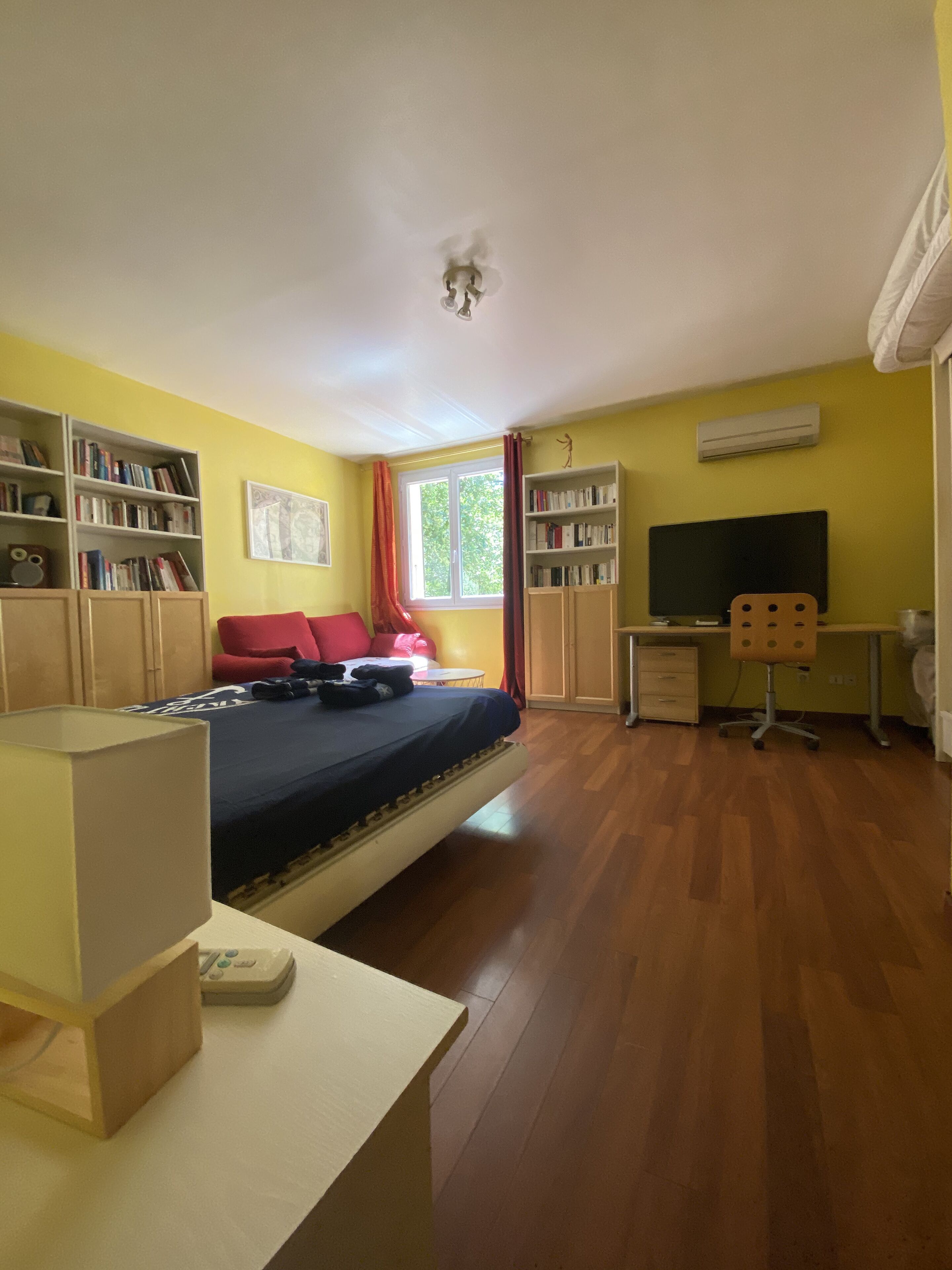 Un dormitorio con una cama, un escritorio y estanterías.