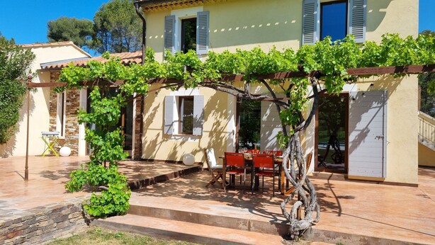 A two-story house with a patio area, a pergola with vines, and a dining table set for two. - 5-star rated air-conditioned house with swimming pool for 6 (Cabriès)