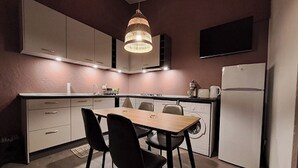Una cocina compacta con una mesa de comedor, sillas, lavadora y refrigerador.