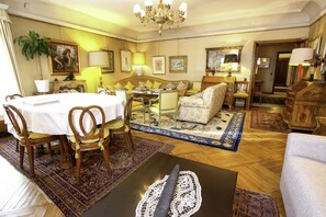 Ein stilvoll eingerichtetes Wohnzimmer mit rundem Tisch, mehreren Stühlen, einer Couch und einem Couchtisch.