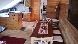 Una cucina accogliente con mobili in legno, un tavolo da pranzo con sedie e un'ampia finestra.
