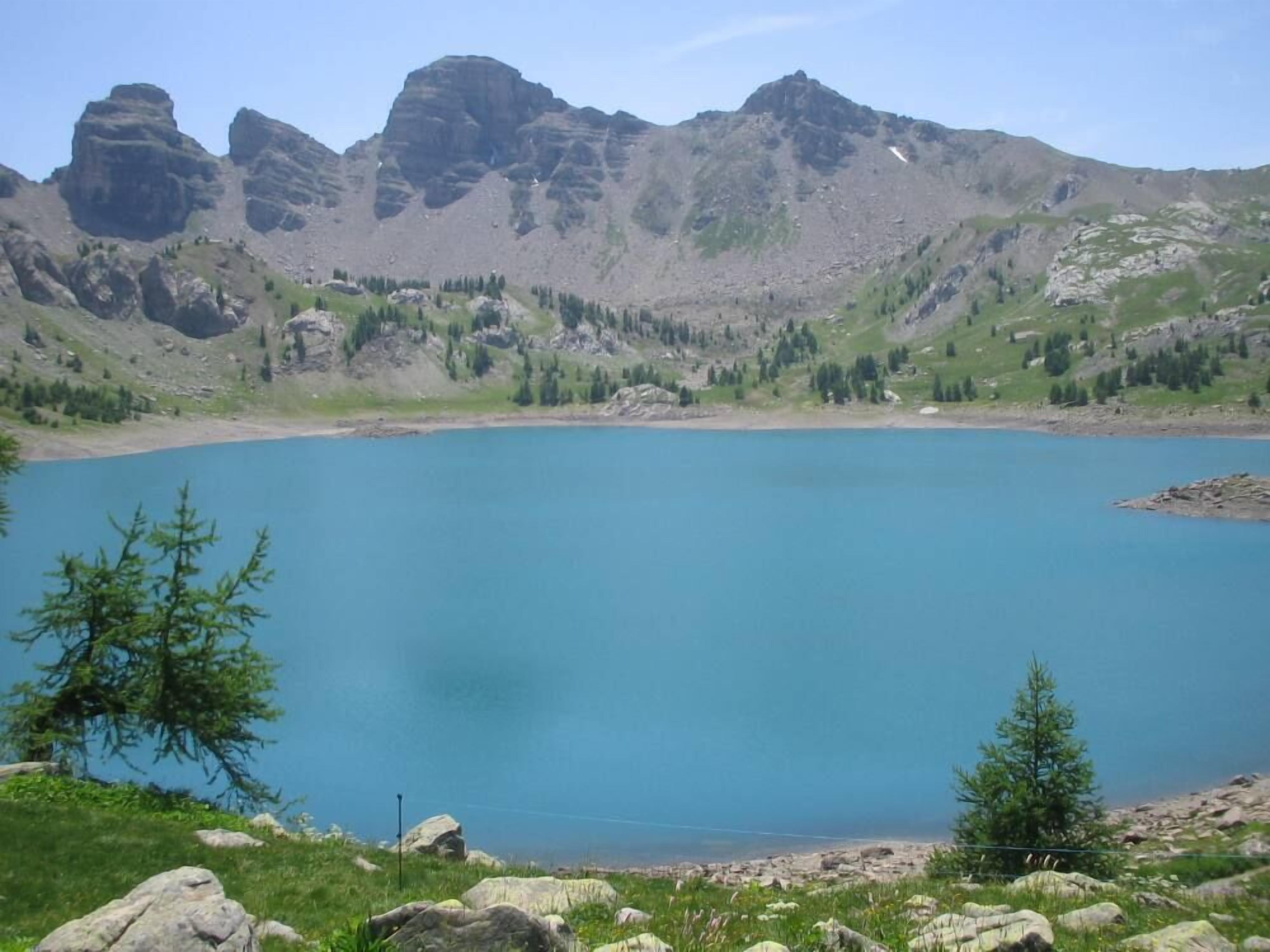 A mountain lake with rocky terrain and sparse vegetation.