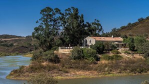 A house by a river with a view of the surrounding landscape.