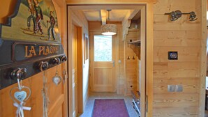 Un pasillo interior de madera con una puerta identificada con 