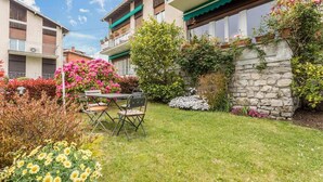 A courtyard with a table and chairs, surrounded by flowering plants and a stone wall. - Apartment - Bellagio House of the Sun (Bellagio)