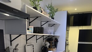 A modern kitchen with a built-in washing machine, a coffee maker, and a microwave.