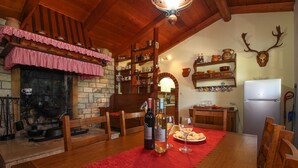 Una cocina acogedora con un tapete rojo, muebles de madera, una chimenea y varios utensilios de cocina en estantes.
