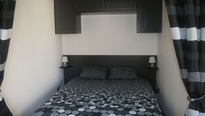 A bed with a patterned bedspread, two bedside lamps, and a dark headboard.