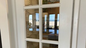 Une porte blanche avec des panneaux en verre dépoli et un trou de serrure.