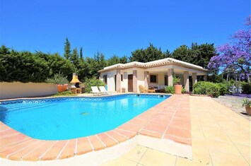 Villa has pool to the side with citrus fruit trees to the front
