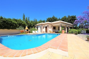 Villa has pool to the side with citrus fruit trees to the front