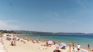 A beach with people sunbathing and swimming, umbrellas, and a clear sky. - Luxury  apartment  in an Art Nouveaux House Cavalaire Sur  Mer, near St Tropez (Cavalaire-Sur-Mer)