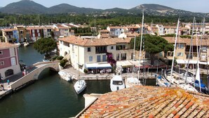 A coastal town with a marina, buildings with red-tiled roofs, and a bridge over the water. - Luxury  apartment  in an Art Nouveaux House Cavalaire Sur  Mer, near St Tropez (Cavalaire-Sur-Mer)