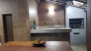 Una cocina moderna con una mesa de madera, un cuenco de fruta y una estatua decorativa.