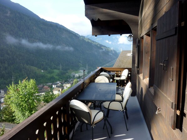 A balcony with a table and chairs overlooking a mountainous landscape. - 4 * chalet: top equipment, fireplace, free Wi-Fi, near ALETSCHARENA (Breiten ob Mörel)