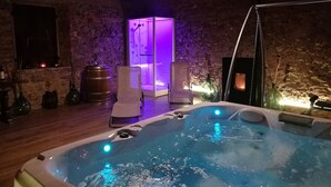 A hot tub in a rustic stone room with a wooden ceiling, a glass-enclosed shower, and a wooden barrel. - Apartment in Country Villa and  SPA (Vicchio (Firenze))