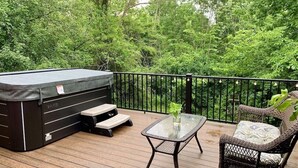 A deck with a hot tub, a glass table, and wicker chairs. - Peaceful Quiet Getaway in Amish Country!10 min. to Berlin & Walnutcreek. #hotub (Dundee)