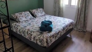 A bedroom with a bed, two hanging lamps, a fan, and a window with curtains. - La Marmandia - Rural house in the heights of western Reunion (La Saline Les Hauts)