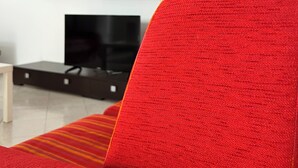 A modern living room with a red sofa, a red cabinet, and a black entertainment unit. - CASA FABRIZIO WITH VERANDA SEA VIEW AND TOWN CENTRE! OFFER € 200.00. INTERNET FR (Balestrate)