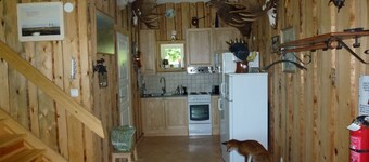 House With An Unique Gathering Of Hunting Trophies. View Of The Pond & Village