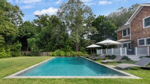 A rectangular swimming pool with a wooden deck and lounge chairs. - Brand New in the Heart of East Hampton Village with Pool (East Hampton)