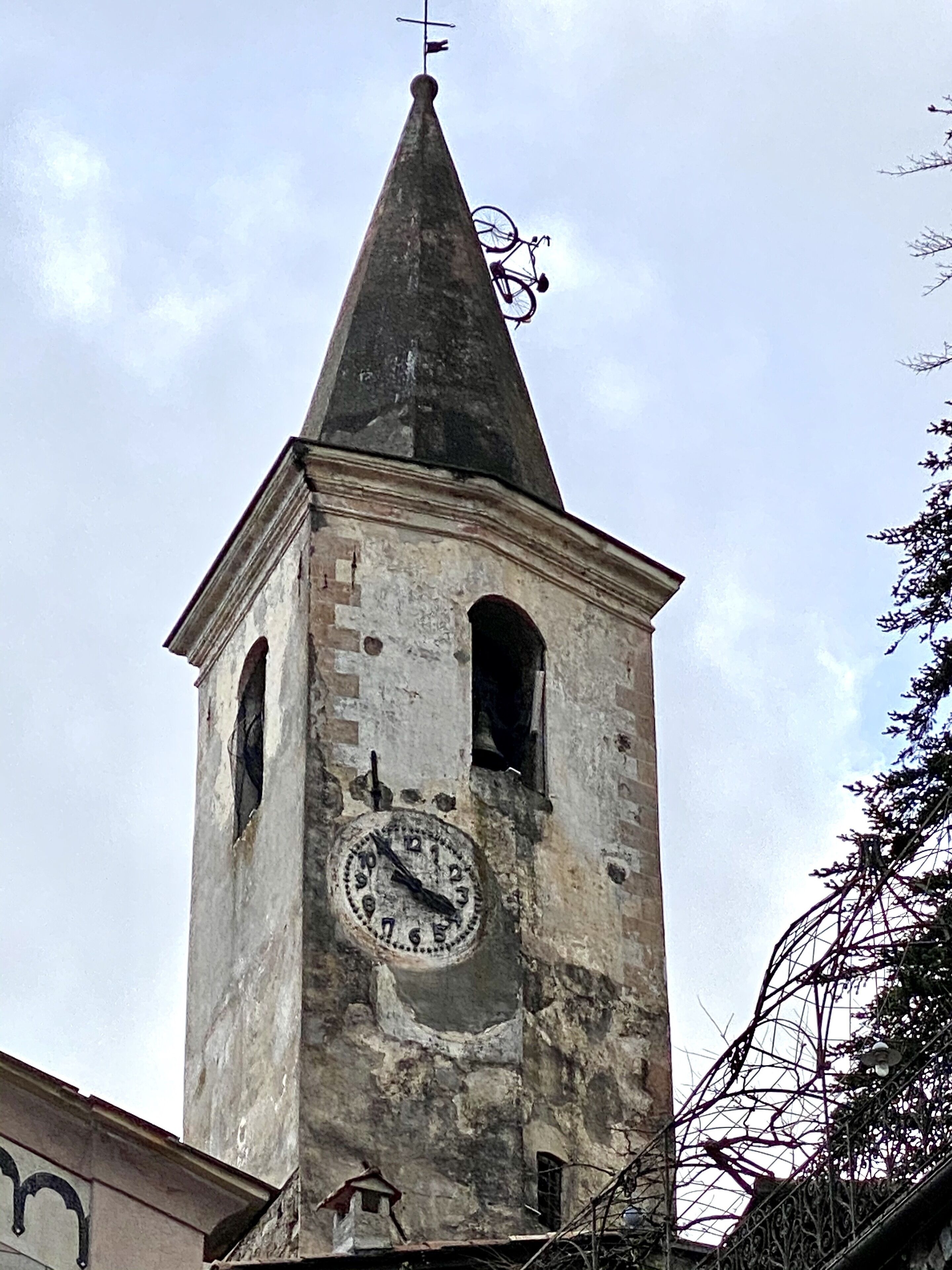 Une tour dotée d’une horloge, d’une girouette et d’une petite fenêtre.