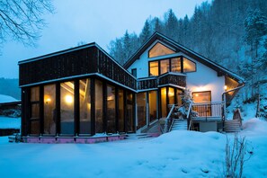 A modern house with large windows, a staircase, and a snow-covered landscape. - Wellness privát Štyri Lipy (Liptovske Revuce)