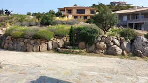 A stone wall with a variety of plants and a building in the background. - Apartment/ flat - Sari SolenzaraHouse with character (Sari-Solenzara)