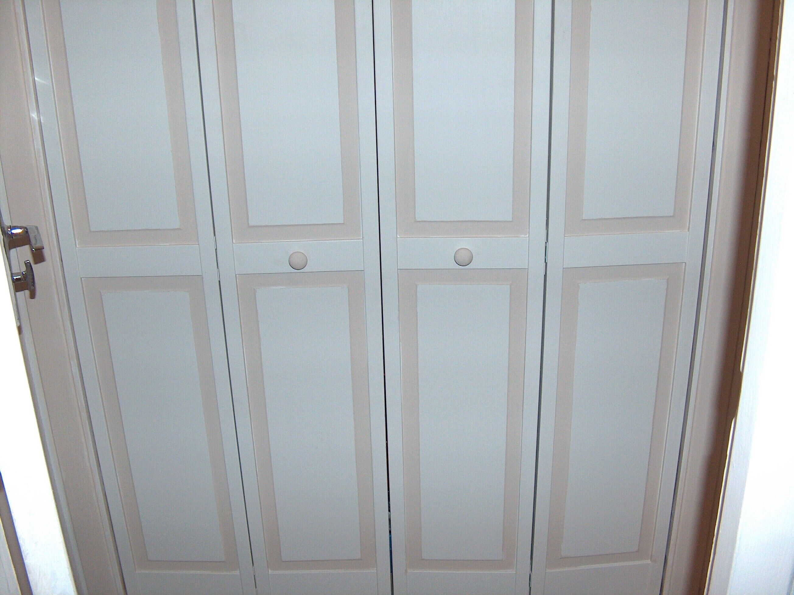 Un conjunto de puertas blancas con un diseño sencillo, cada una con dos manijas.