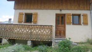 Ein rustikales Gebäude mit Holzfassade, Steinuntergrund und dekorativem Holzzaun.