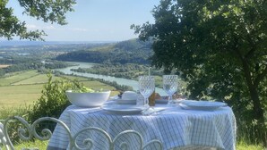 Ein Tisch draußen mit Blick auf einen Fluss und Hügel.